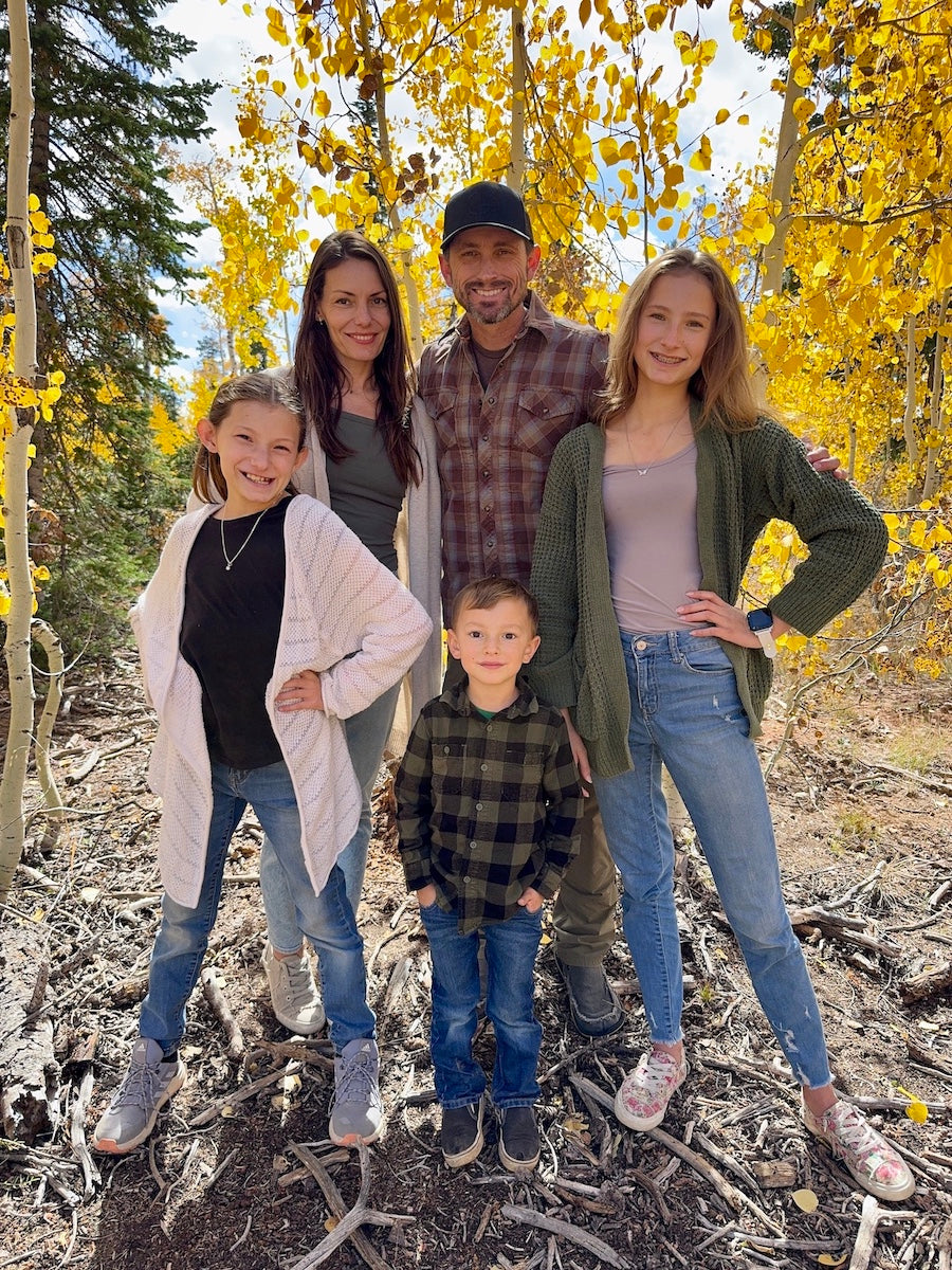 A family photo taken in the fall season amidst a grove of aspen trees of a traditional, American family of 5.
